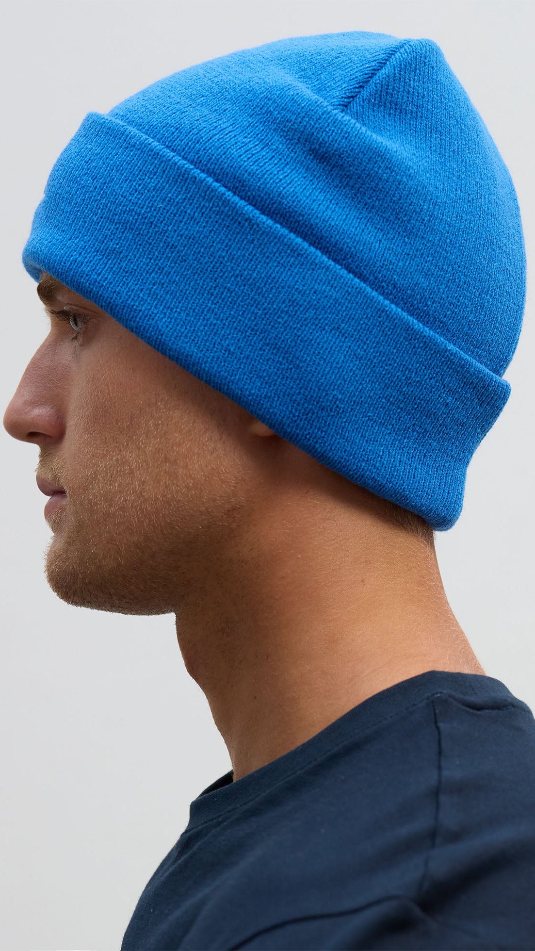 A person wearing a blue knitted beanie hat.