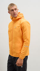 A person wearing an orange windbreaker jacket with a hood, zipper, and reflective details.