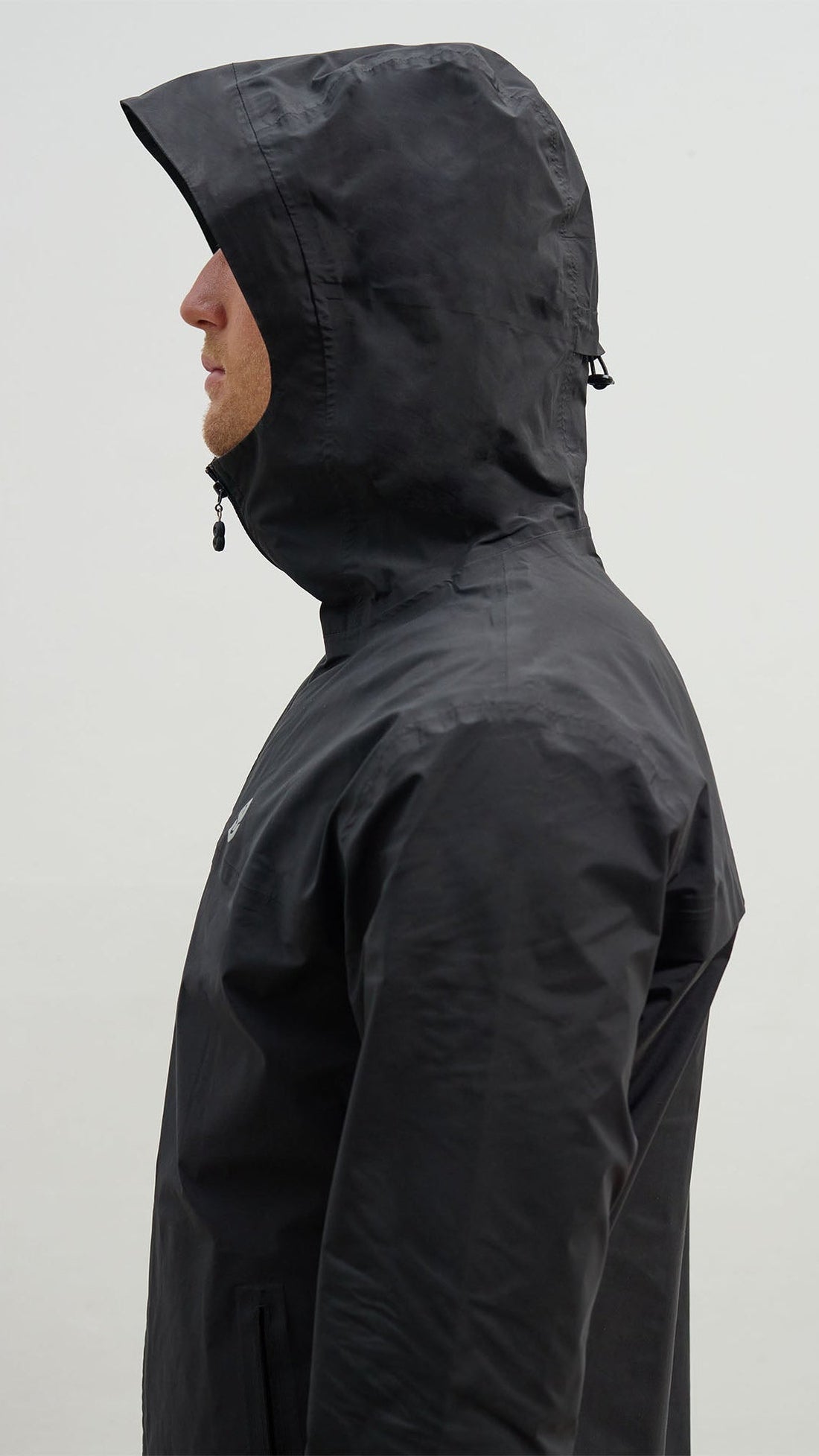 OCL black windbreaker with the hood up, side view