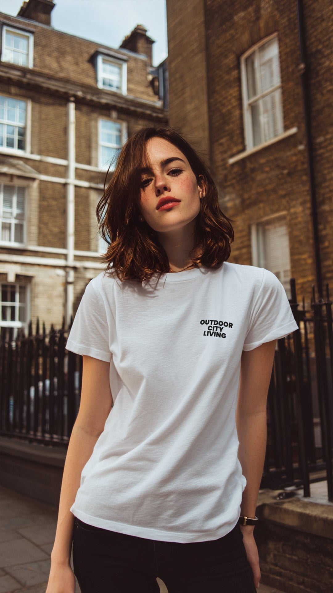Woman wearing a white t-shirt with text in an urban setting